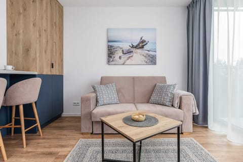 A cozy living room with a wooden coffee table, stylish chairs, and modern artwork on the wall.
