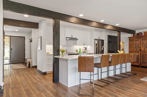 Kitchen looking into entrance hallway with cubbies and coat hooks