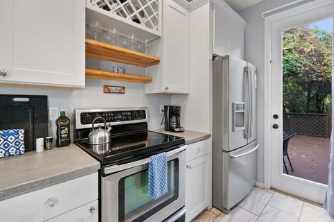 Kitchen overlooks a back patio with additional dining and fire pit (guests must provide their own firewood)
