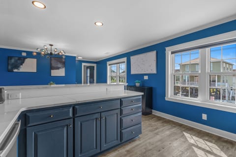 Enjoy morning light and bold coastal color from the kitchen. With polished counters, navy cabinetry, and a wide open layout, this space makes meal prep feel effortless.
