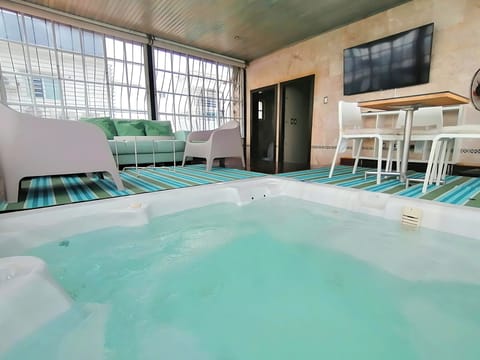 Hot tub area with TV and half-bathroom.