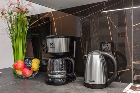 A kitchen countertop adorned with a coffee maker, electric kettle, and a vase of fresh flowers, creating a welcoming atmosphere.