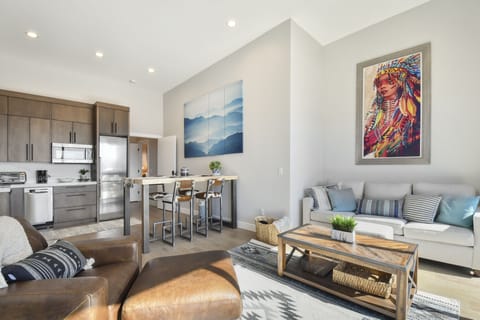 Stylish open-concept kitchen and lounge with vibrant art and natural light.