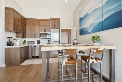 Warm kitchen and dining space with mountain art and rustic-modern charm.