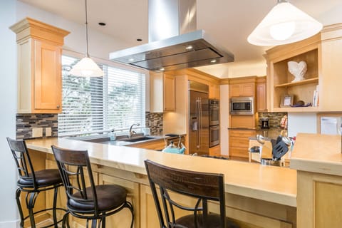 Kitchen features professional-grade stainless appliances, including a double oven, a 5-burner gas cooktop, and a small appliance garage.