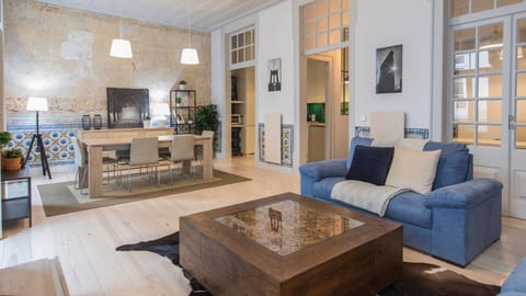 Gather with loved ones in this expansive open-plan living and dining area, offering plenty of room to relax on the plush sofa or enjoy memorable meals together amidst charming local design touches. The high ceilings and large doorways enhance the feeling 