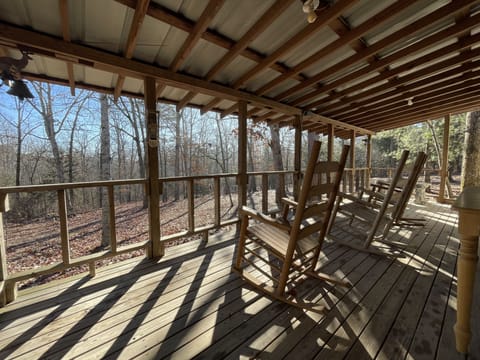Large porch with rockers and table, overlooking the woods
