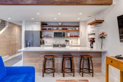 Fully-equipped kitchen with high-quality stainless steel appliances, plenty of countertop space, and breakfast bar seating