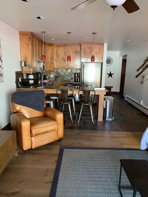 View of the hallway, fully-equipped kitchen, and lounge chair in the living room