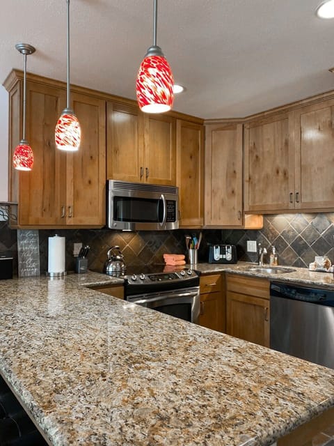 Fully-equipped kitchen with high-quality stainless steel appliances, and a breakfast bar with 6 stools