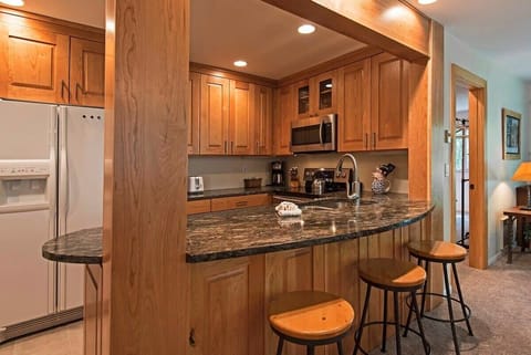 Fully-equipped kitchen with breakfast bar stool seating