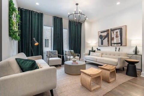 Living room designed for relaxation with ample seating, cream sofas, and green accents.