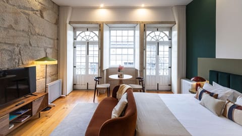 This inviting studio space blends historic stone walls with modern comforts, creating a cozy retreat where you can relax after a day of exploring. Enjoy a quiet evening watching TV or reading in the comfortable seating area.