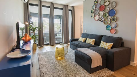Unwind on the plush sectional sofa in this stylish living room, perfect for catching up on your favorite shows or simply relaxing after a day of exploring. Ample natural light from the balcony doors creates a bright and inviting atmosphere for your comfor