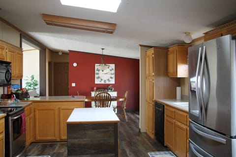 Kitchen with refrigerator,stove and  dishwasher and lots of pots and pants.