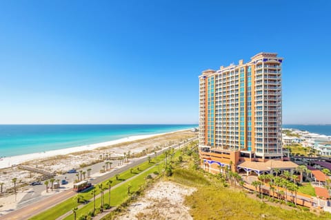 This beachfront property offers direct access to pristine white sand shores and stunning turquoise Gulf waters, surrounded by lush landscaping and swaying palms.