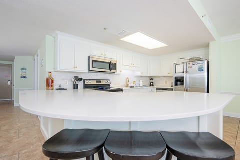 Gather around the spacious kitchen counter, perfect for casual meals and conversations in a bright kitchen