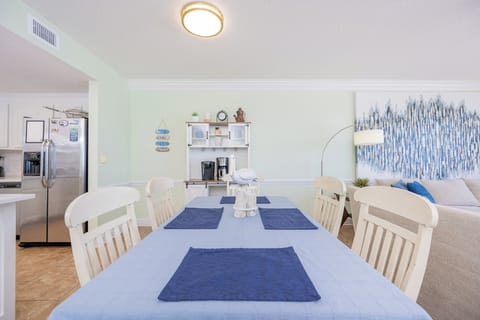 Dine at the spacious table, surrounded by coastal decor and a welcoming atmosphere perfect for gatherings