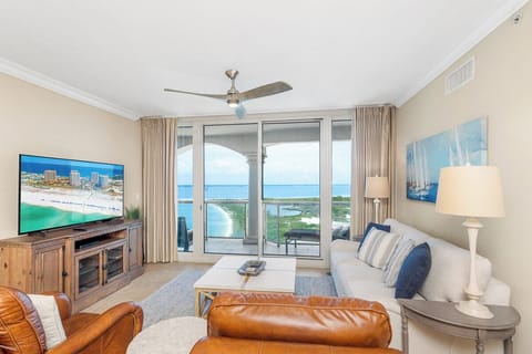 Your coastal retreat awaits with stunning views framing this bright living room, where you'll unwind on plush seating while coastal breezes flow through.