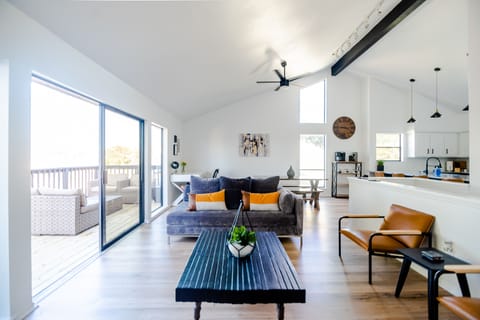Open concept living area with the kitchen, dining, living and deck area. 