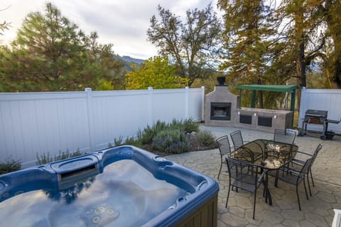 Private patio with fireplace, hot tub, and BBQ