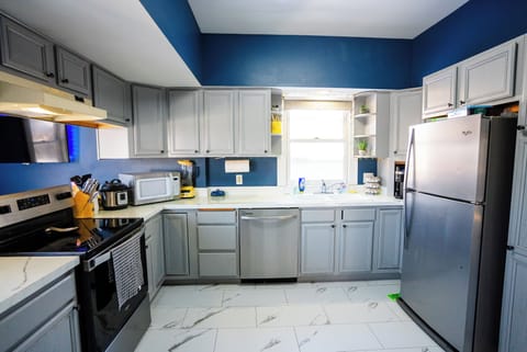 Full kitchen with breakfast bar, stainless appliances and cooking basics.