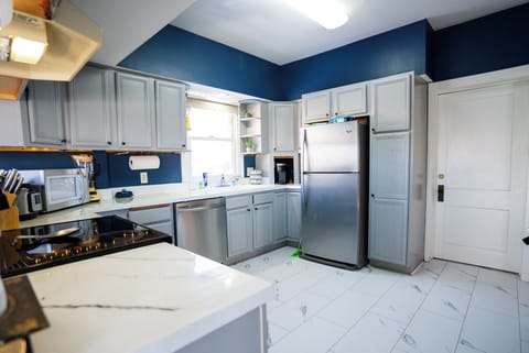 Full kitchen with breakfast bar, stainless appliances and cooking basics.