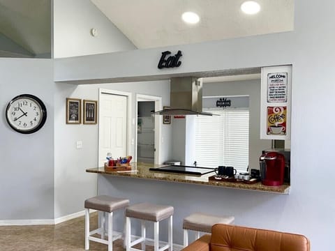 White bar stools to sit and enjoy the kitchen and coffee area.