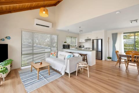 The open plan layout, coastal charm, log fire, timber-lined ceilings, and large windows make the home feel bright and airy