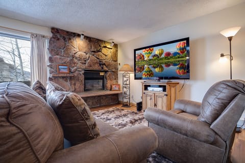 Sink into plush recliners by your stone fireplace while enjoying the large TV—perfect for cozy movie nights after mountain adventures.