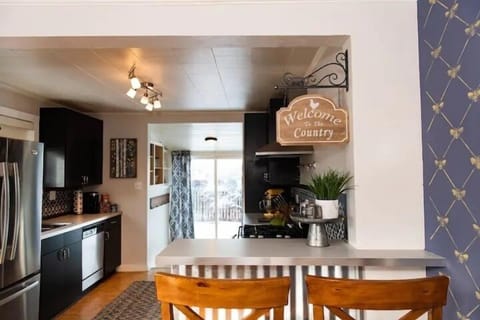 A large kitchen with extra bar seating to sit and chat with the cook as they prepare a home cooked meal.