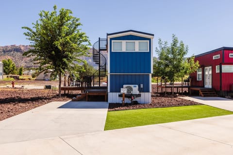 Front view of the home with dedicated parking directly in front for easy arrival and unloading. Enjoy a clean, landscaped setting within a well-maintained tiny home community designed for convenience and comfort.