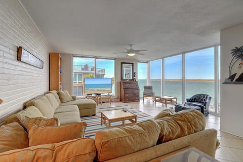Relax in your expansive living room with stunning ocean views through floor-to-ceiling windows. Sink into comfortable seating while enjoying breathtaking water vistas.