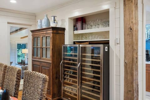 Rustic dining area featuring a dual wine cooler and wooden cabinet for glassware storage.