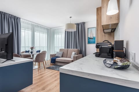 A combined view of the living room and kitchen area, featuring modern blue cabinetry and a comfortable seating area.