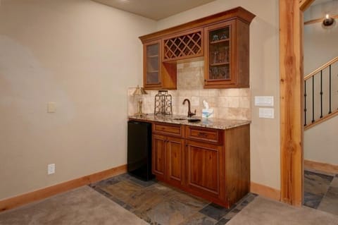 Basement wet bar off of family room with mini fridge.