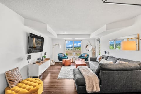 Living room with a large Smart TV, cozy seating options and access to the main private balcony.