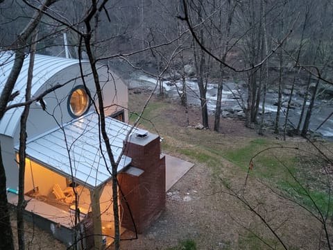 Outdoor kitchen with fireplace and 50" TV overlooking Elk River