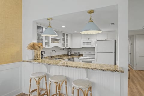 Your fully equipped kitchen features granite counters, stainless appliances, and a breakfast bar perfect for morning coffee or casual meals.