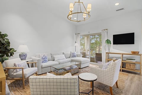 Settle into your spacious living area featuring comfortable seating, elegant lighting, and French doors opening to your private balcony retreat.