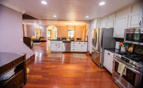 Large refrigerator and gas stove. Microwave is above the stove