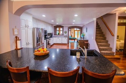 4 swivel chairs at the bar looking into the kitchen