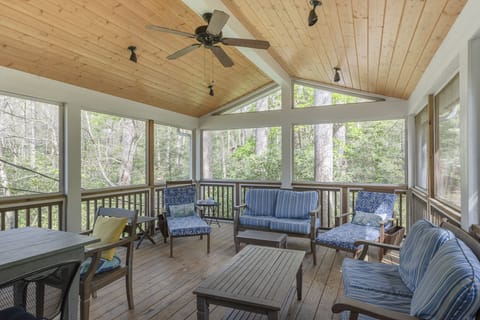 A serene screened porch that provides a peaceful view of Flat Creek, allowing guests to enjoy the natural surroundings comfortably