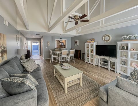 Natural light fills the open living space featuring tall, vaulted ceilings