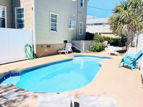 Large pool area with chairs and loungers
