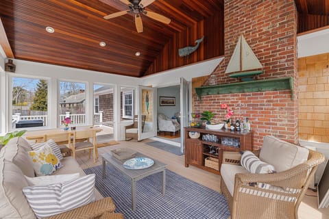 Spacious sunroom with vaulted mahogany ceilings and dining table.