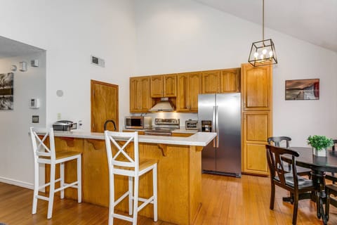 Open kitchen with all new stainless steel appliances and bar top seating