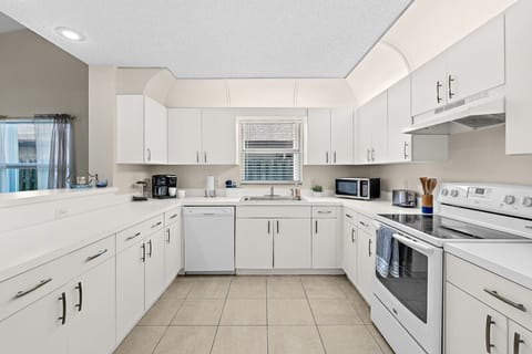 Fully equipped kitchen with flat stove top, refrigerator and freezer, dishwasher, coffee maker and more. (food and coffee not provided)