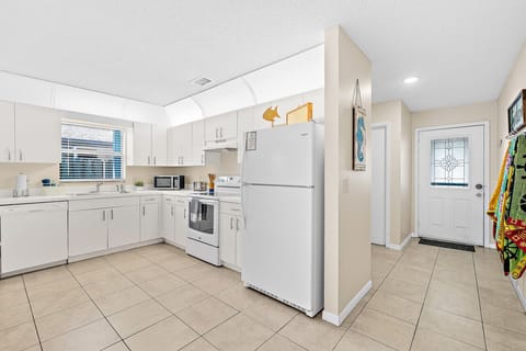 Fully equipped kitchen with flat stove top, refrigerator and freezer, dishwasher, coffee maker and more. (food and coffee not provided)