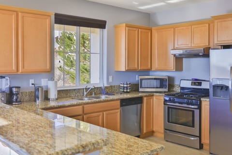 The kitchen is equipped with stainless steel appliances and cookware